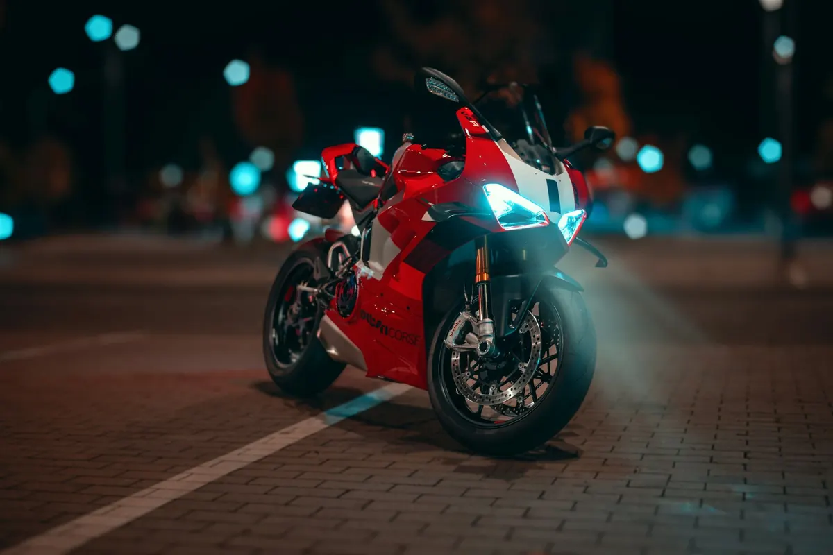 Rotes Sportmotorrad nachts mit eingeschaltetem Licht